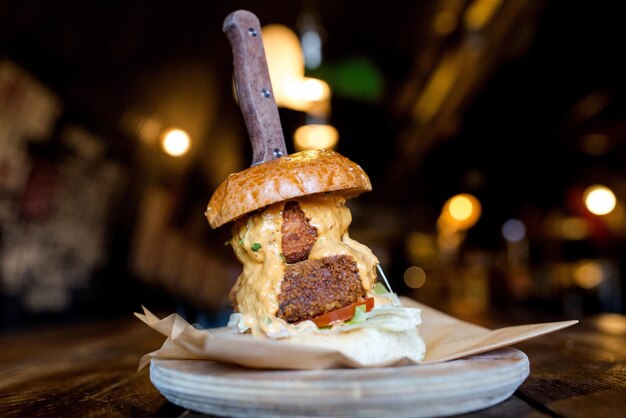 Primer plano de una sabrosa hamburguesa en un plato de madera en el restaurante