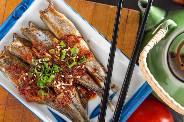 Primer plano de sabroso pescado Shishamo a la parrilla con salsa de soja en un plato en resolución 4K