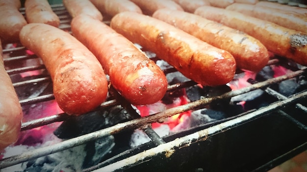 Foto primer plano de una salchicha cocinada en una parrilla de barbacoa