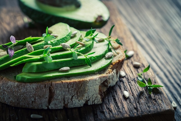 Primer plano de un sándwich con hierbas y semillas de aguacate