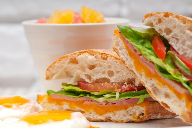 Primer plano de un sándwich con huevos fritos servidos en un plato