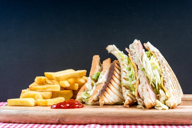 Foto primer plano de un sándwich con papas fritas en la tabla de cortar