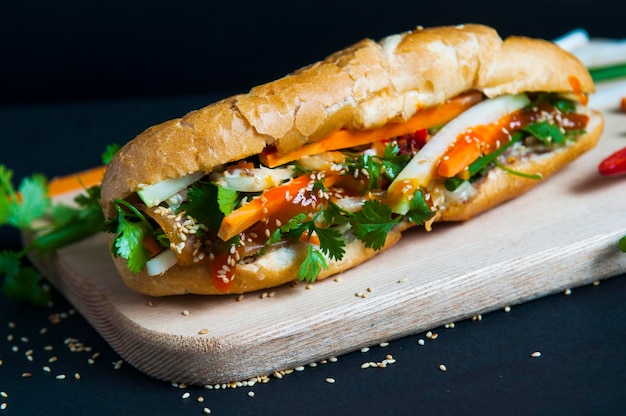 Primer plano de un sándwich en una tabla de cortar sobre un fondo negro