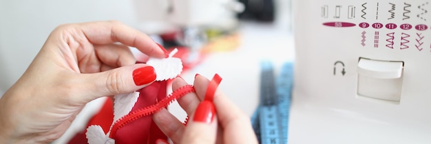 Primer plano de una sastre profesional que usa una máquina de coser para un interesante proceso de trabajo de