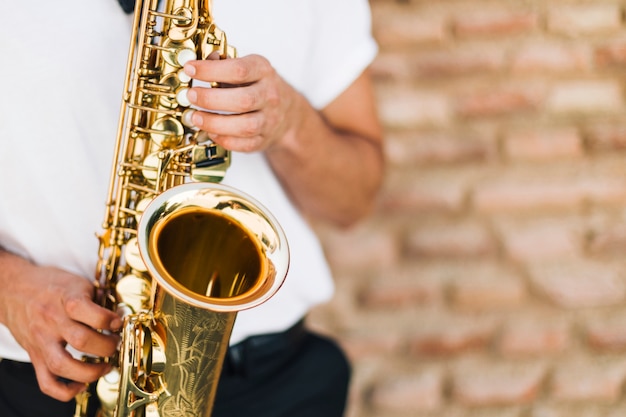 Foto primer plano de saxofon tocado por el hombre