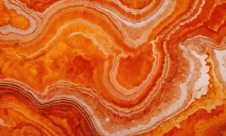 un primer plano de una sección de un gran mármol rosa naranja y blanco