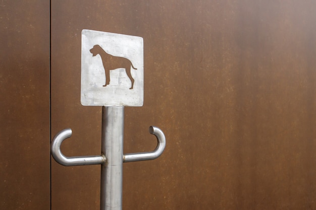 Primer plano de una señal de estacionamiento para perros al aire libre. Un lugar para una correa para perros que esperan a sus dueños en la calle. Coloque una correa, en lugares públicos o en la entrada de la tienda. Copie el espacio.