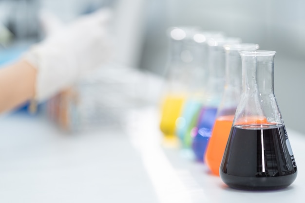 Primer plano y sesión de enfoque selectivo de un microscopio, tubos de ensayo médicos con líquido y otros equipos de laboratorio modernos en una sala de laboratorio. Educación foto de stock