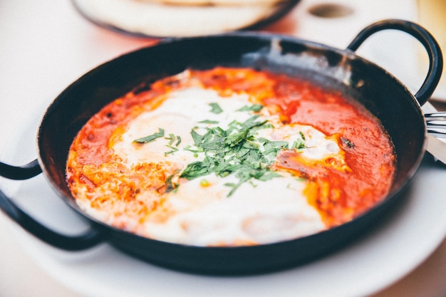 Foto primer plano de la shakshouka en la sartén