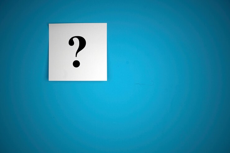 Foto primer plano del signo de interrogación en papel contra un fondo azul