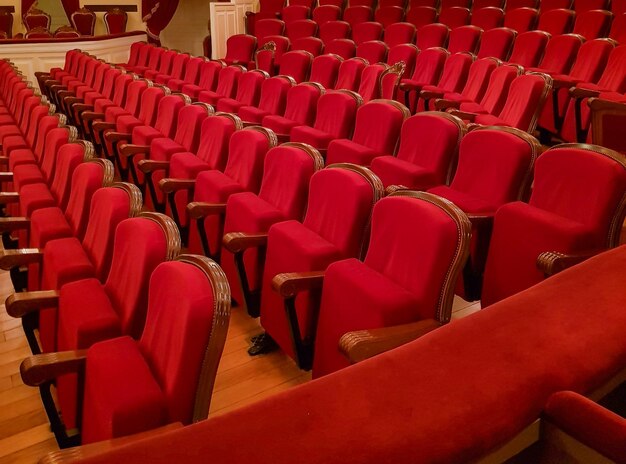 Primer plano de sillas vacías clásicas tradicionales tapizadas en terciopelo rojo el interior del teatro