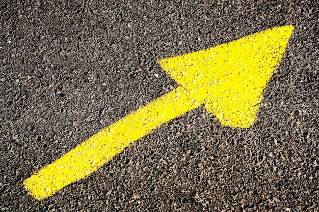 Foto primer plano del símbolo de la flecha amarilla en la carretera