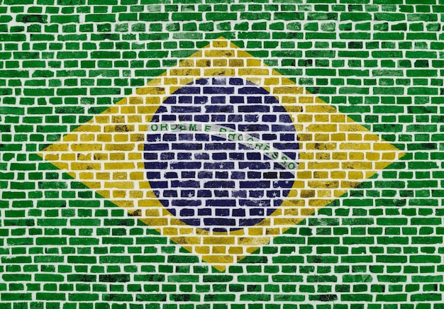 Primer plano sobre una pared de ladrillos con la bandera de Brasil pintada en ella