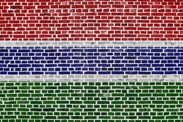 Primer plano sobre una pared de ladrillos con la bandera de Gambia pintada en ella