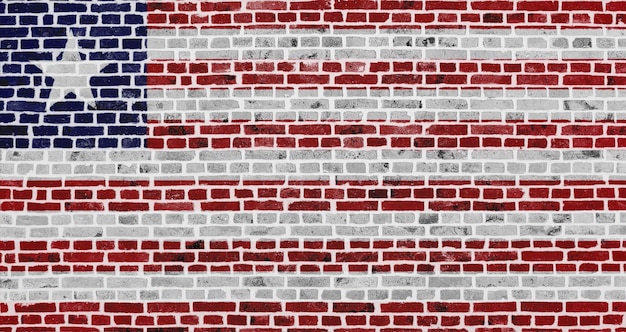 Primer plano sobre una pared de ladrillos con la bandera de Liberia pintada en ella