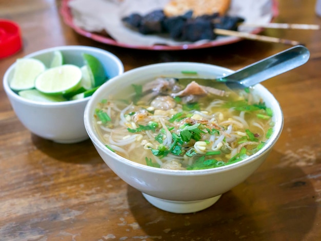 Primer plano de la sopa de carne Soto Daging una sopa tradicional indonesia en la mesa de madera