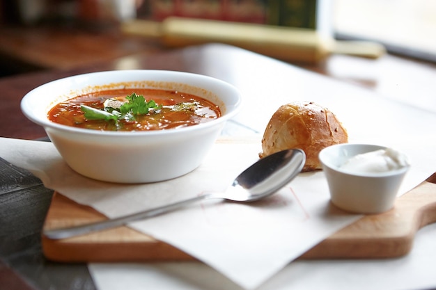 Primer plano de sopa en un cuenco con pan en la mesa