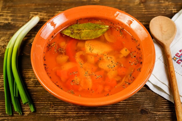 Primer plano de una sopa de verduras en la mesa rústica.