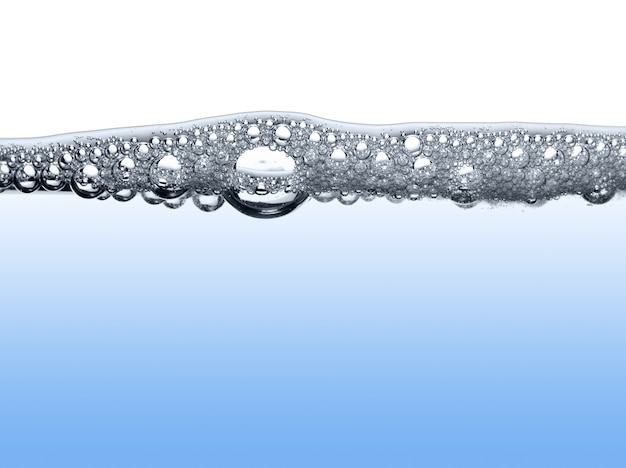 Primer plano de la superficie del agua azul con burbujas