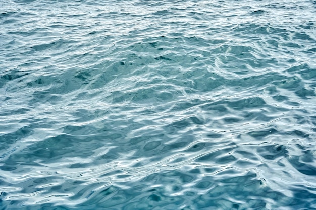 Primer plano de la superficie del paisaje marino de agua de mar azul con pequeñas olas en un día nublado