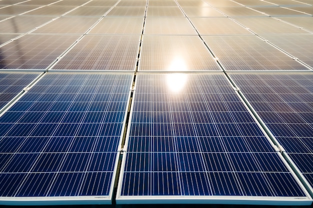 Primer plano de la superficie de los paneles solares fotovoltaicos azules montados en el techo del edificio para producir electricidad ecológica limpia. Producción de concepto de energía renovable.