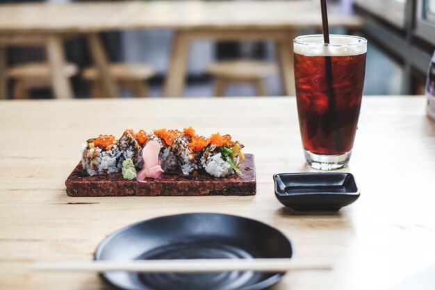 Primer plano de sushi con bebida servida en la mesa