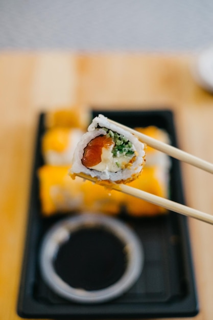 Primer plano de sushi en palillos en el plato