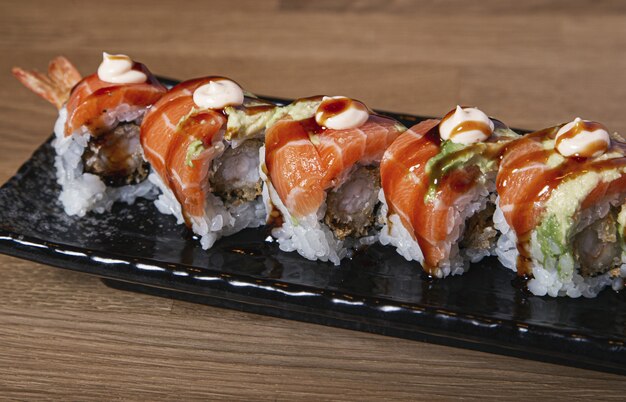 Primer plano de sushi relleno de gambas cubiertas con salmón y aguacate.