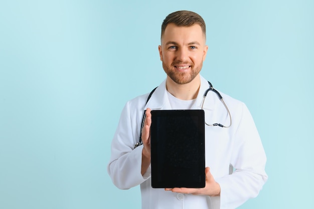 Primer plano de una tableta que se sostiene en las manos de un médico que tiene una bonita carita sonriente.