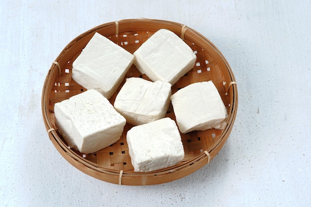 Primer plano de tahu putih crudo o tofu en cesta de bambú