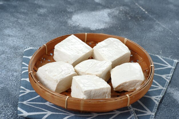 Primer plano de tahu putih crudo o tofu en cesta de bambú