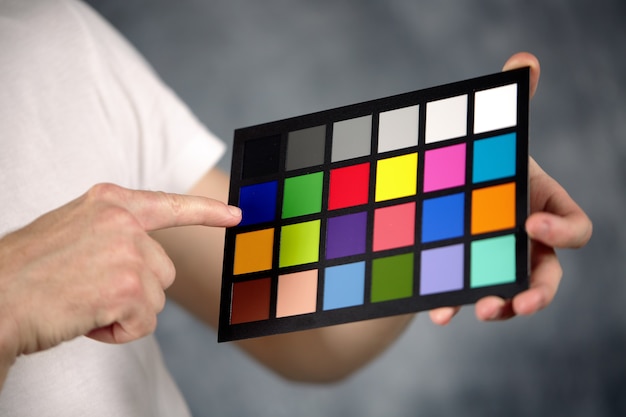 Foto primer plano de una tarjeta colorchecker en las manos