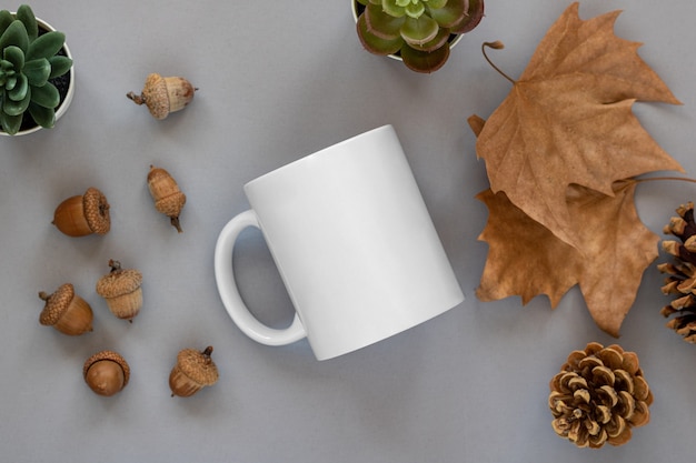 Primer plano de una taza blanca en un entorno de decoración de otoño