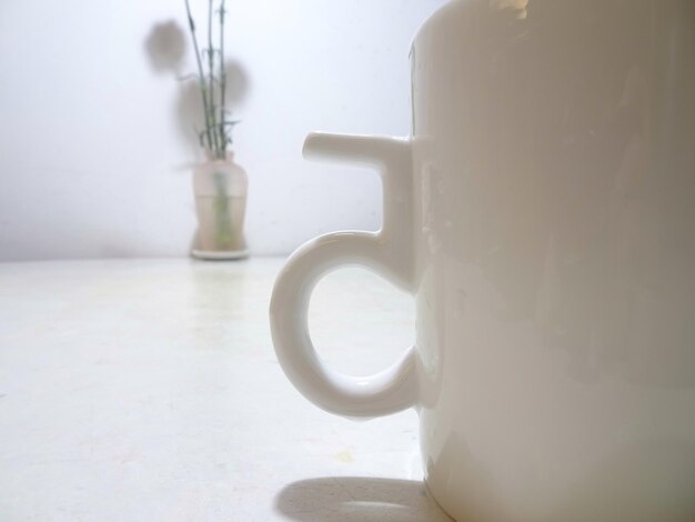 Primer plano de una taza blanca en la mesa en casa