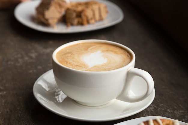 Primer plano de una taza de café y dulces