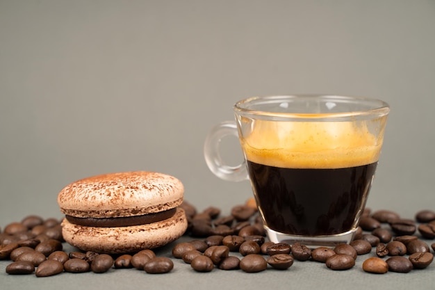 Primer plano de la taza de café esparcida granos de café y galletas macarons