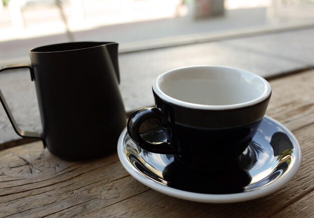 Foto primer plano de la taza de café y la jarra en la mesa