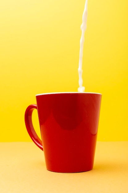 Primer plano de una taza de café en la mesa contra un fondo amarillo