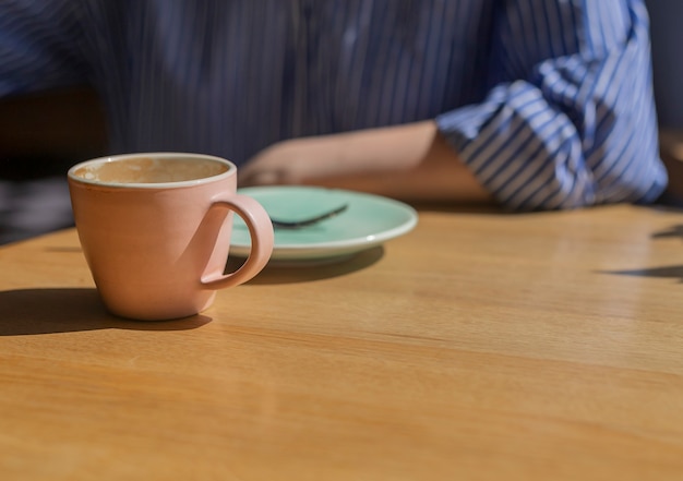 Primer plano de una taza de café y un plato en el desayuno en la cafetería moderna