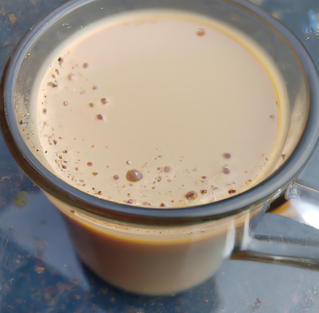 Primer plano de una taza de té chai sobre una mesa de vidrio creada con tecnología de IA generativa