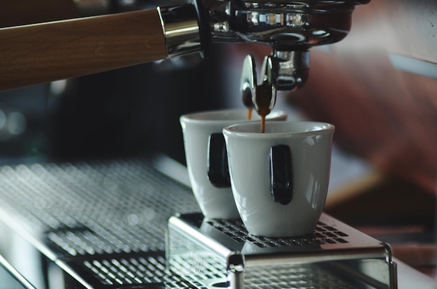 Primer plano de las tazas de café en la máquina de café espresso