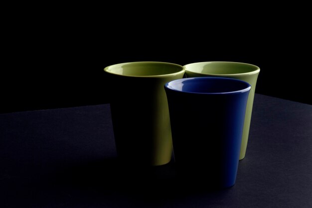Primer plano de tazas de café vacías contra un fondo negro