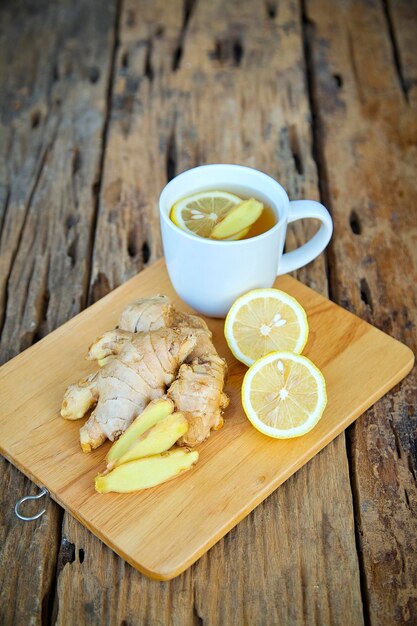 Foto primer plano de té de jengibre con limón con los ingredientes en la mesa