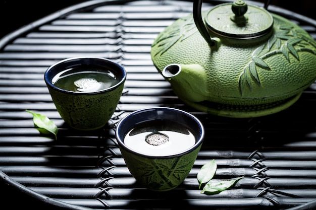 Primer plano de té verde en la mesa de bambú negro