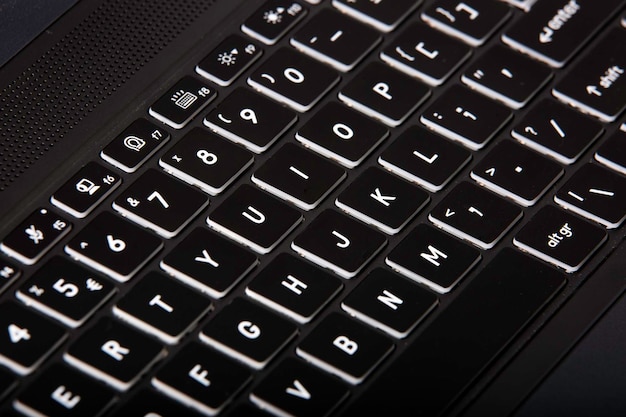 Primer plano de un teclado de computadora negro con letras blancas y números en él