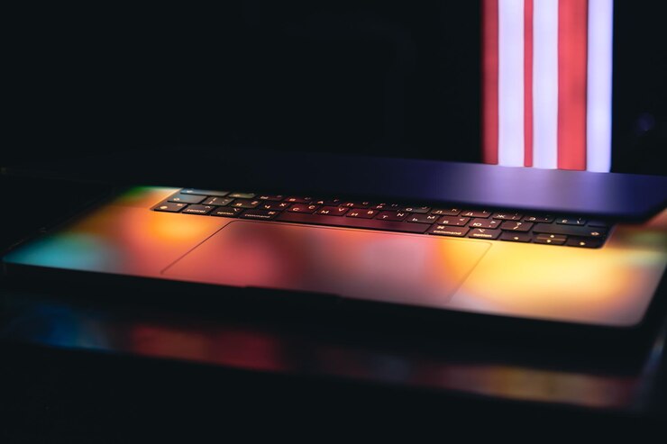 Foto un primer plano del teclado de la computadora portátil con iluminación de neón de colores y teclado retroiluminado