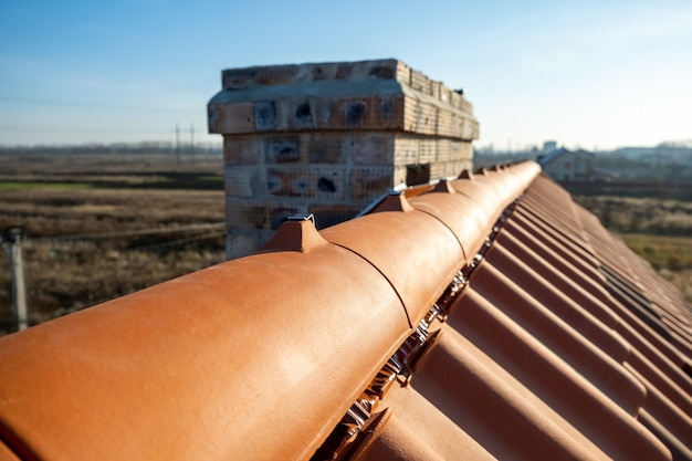 Primer plano de tejas de techo de cerámica amarilla en la parte superior del techo del edificio en construcción.