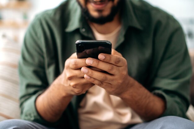 Foto primer plano de un teléfono inteligente en manos de un hombre el concepto de mensajería en línea comunicación en redes sociales navegar por los sitios web leyendo noticias tecnologías inalámbricas aparatos