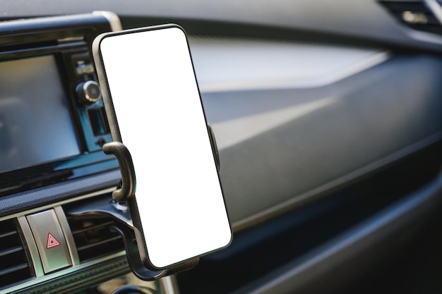 Primer plano de un teléfono móvil en blanco en el coche