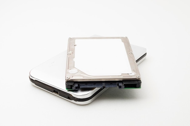 Primer plano de un teléfono móvil con disco duro sobre un fondo blanco